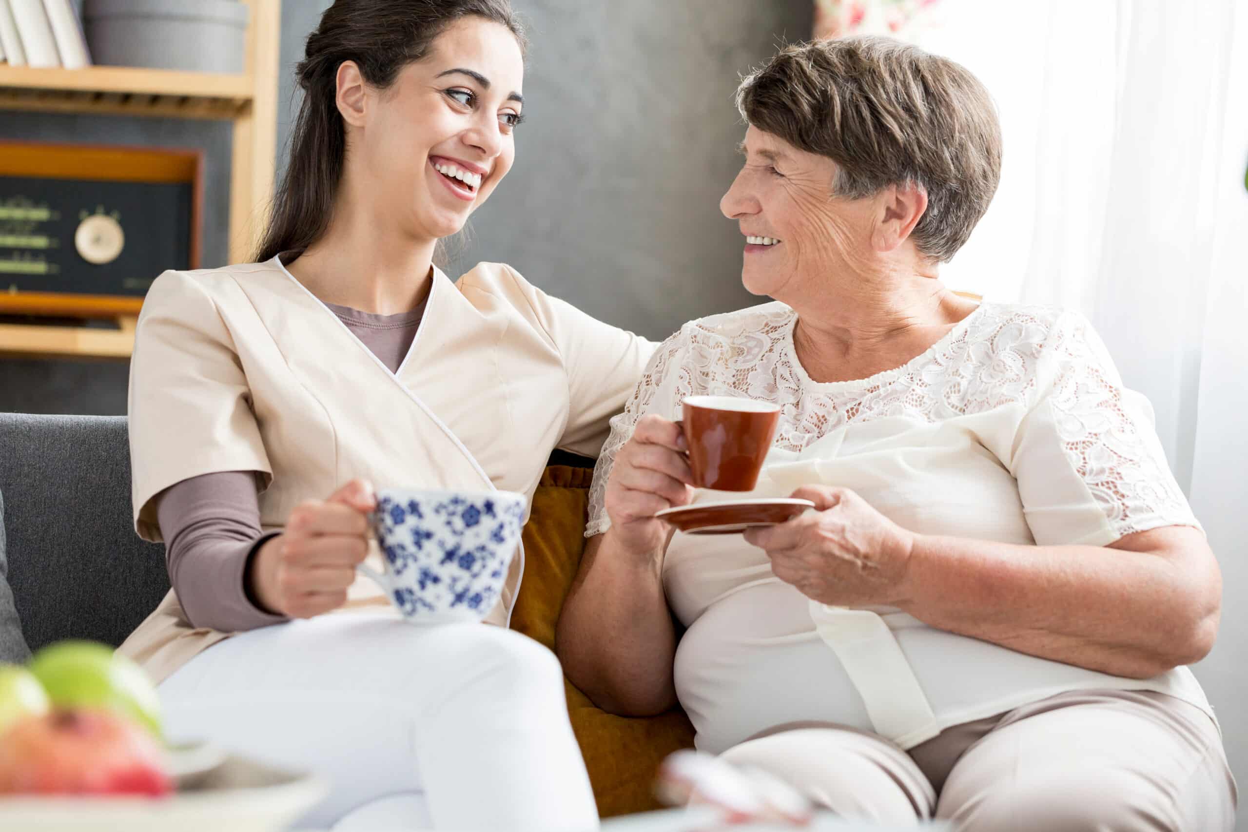 smiling volunteer drinking coffee with a senior